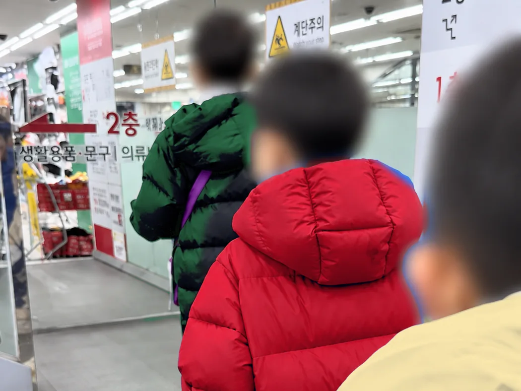 탐험대 세 친구가 뒷모습으로 매장 2층 생활용품·문구 코너로 올라가는 모습