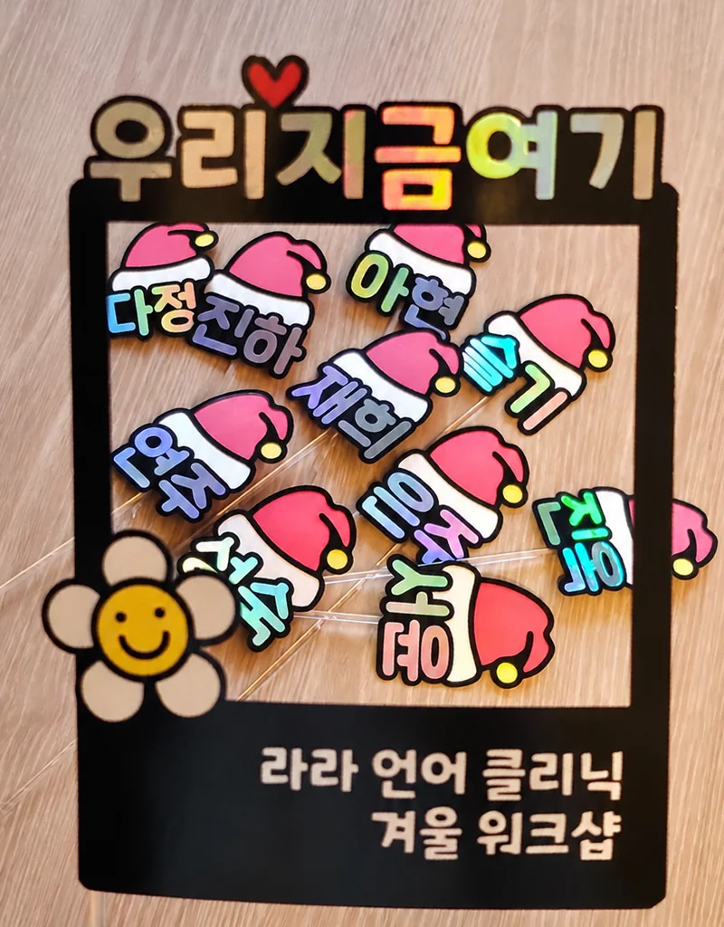 ‘우리 지금 여기, 라라 언어 클리닉 겨울 워크샵’ 포토 프레임 안에 놓인 산타 모자 모양 이름 토퍼들